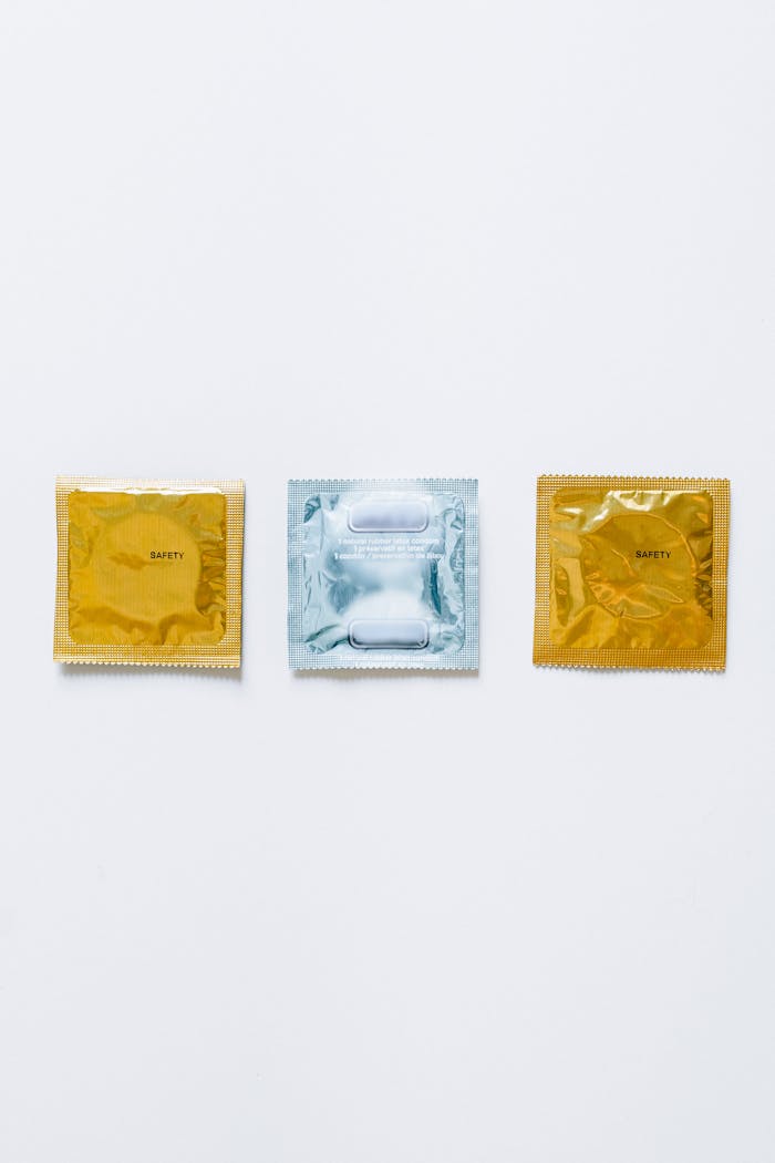 Three condom packages on a white background symbolizing safe sex and protection.